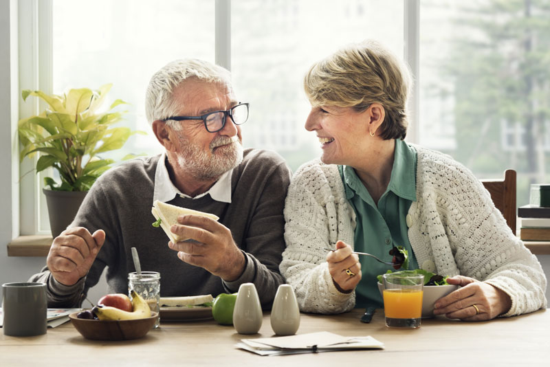 elderly couple eating with their new dental implants